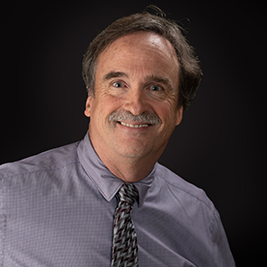 Portrait image, from the shoulders up of a man with moustache